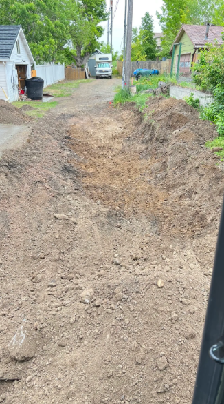 A large pile of dirt is sitting on the side of a dirt road.