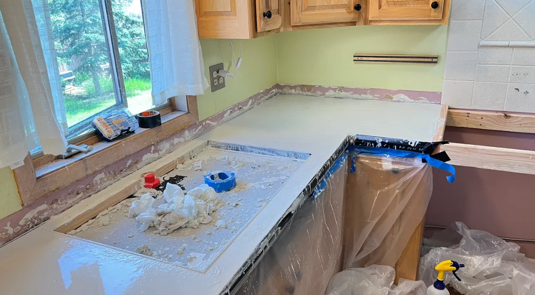 A kitchen counter is being painted in a house.