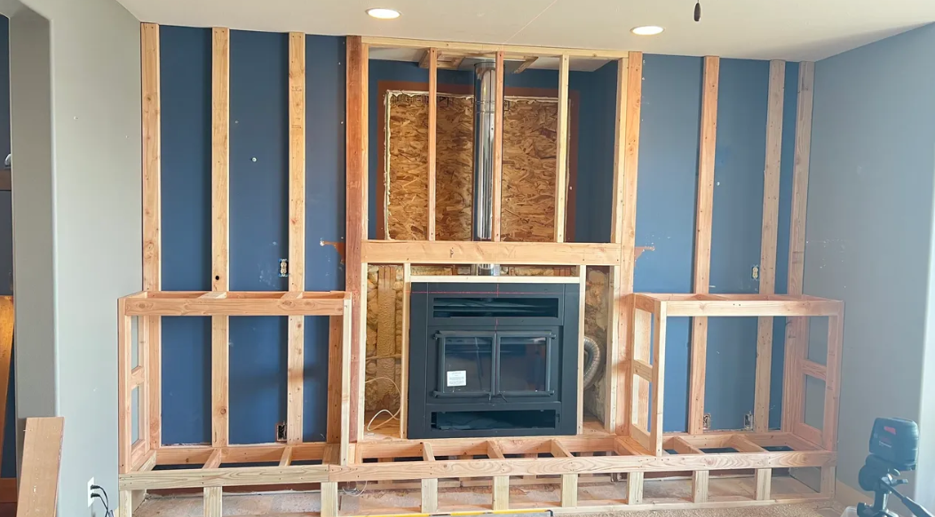 A fireplace is being built into a wall in a living room.