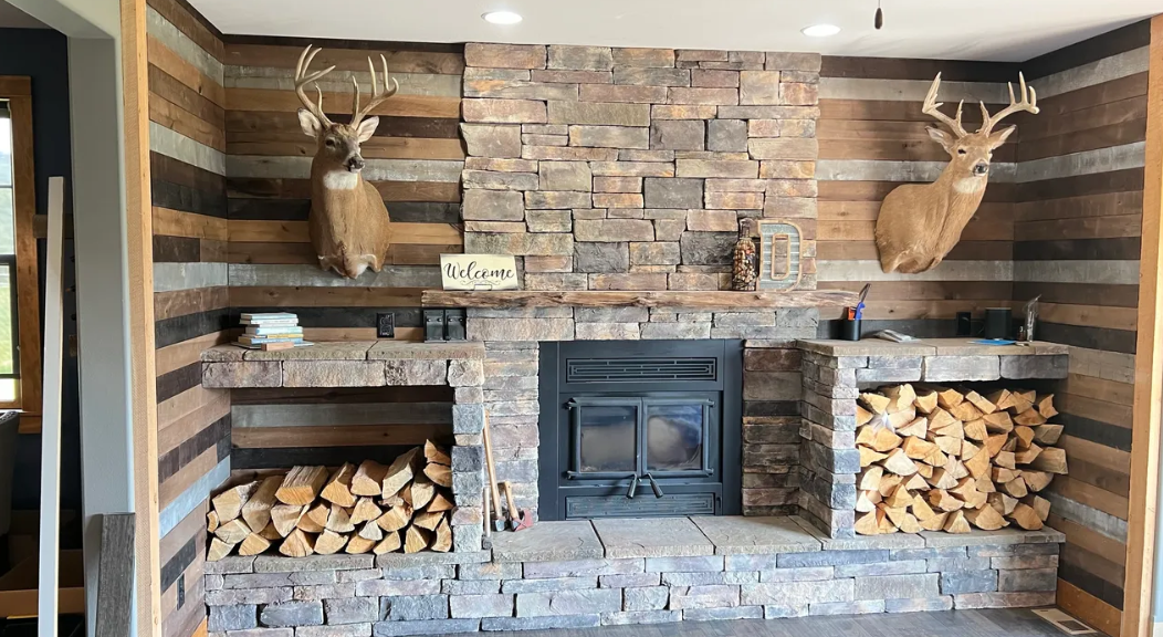 A living room with a fireplace and two deer heads on the wall.