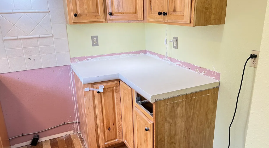 A kitchen with wooden cabinets and a white counter top.