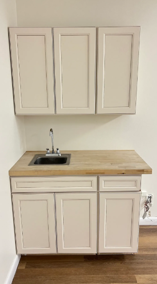 A small kitchen with white cabinets and a sink.