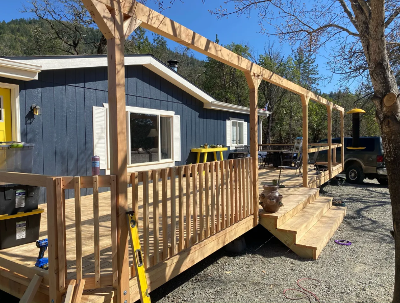 A blue house with a wooden deck in front of it