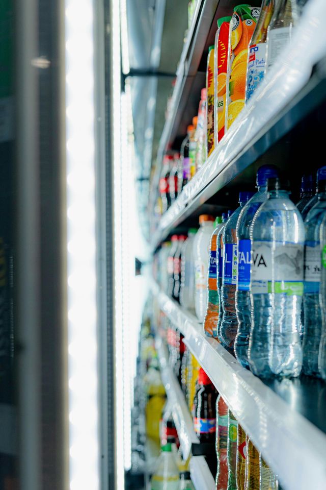 Aisle shelf stocked with bottled water and colorful packaged snacks in a store