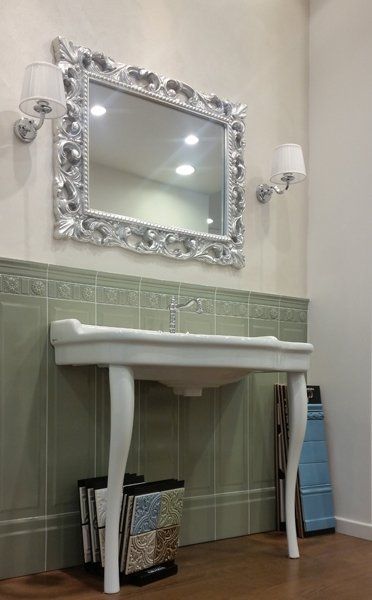 bagno con lavabo in marmo e specchio con cornice