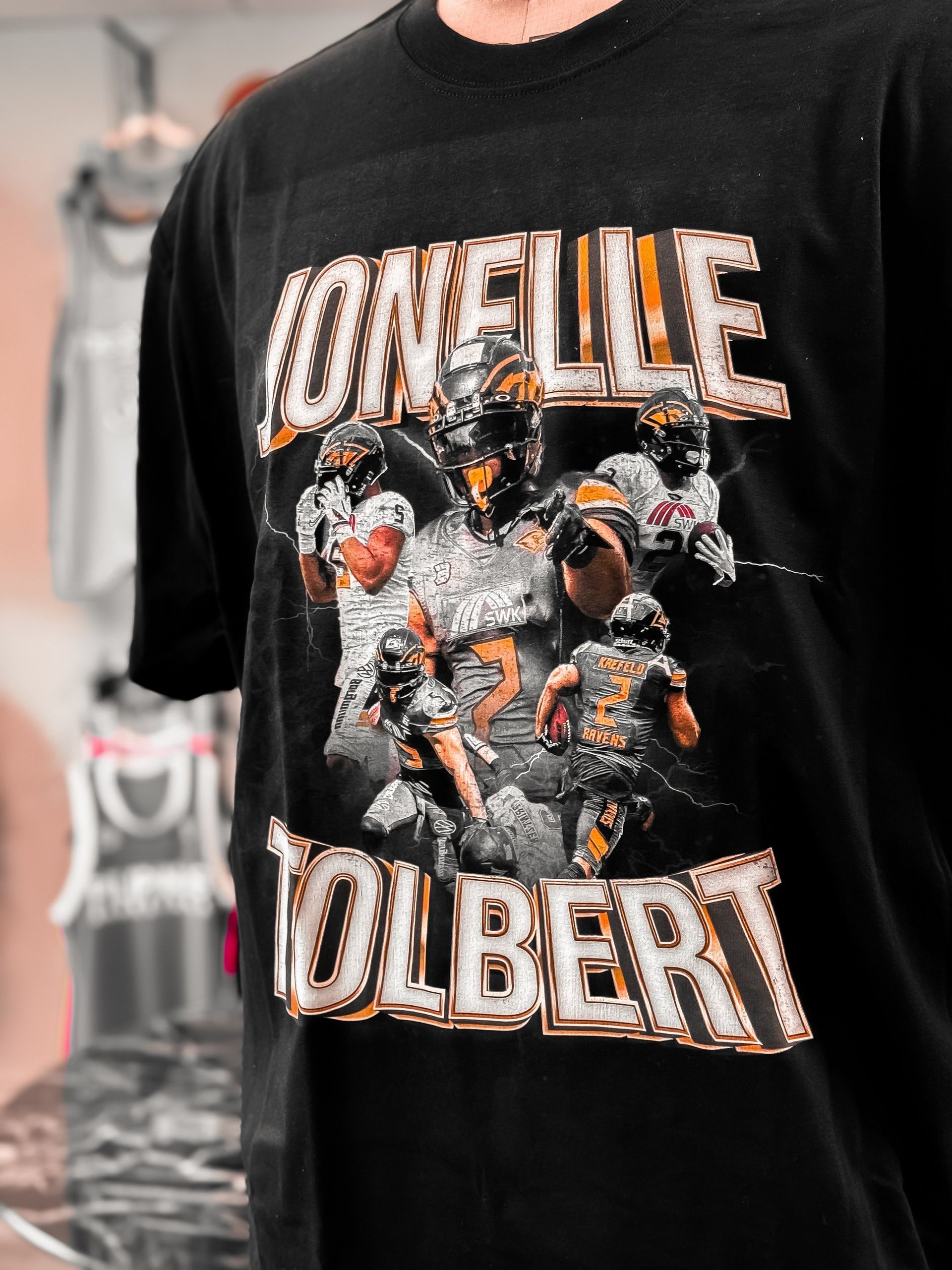 A man is wearing a black t-shirt that says loneville olbert