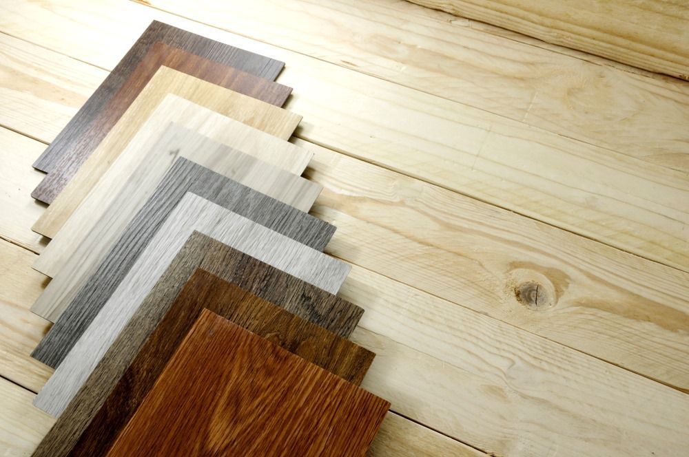 A Variety of Wood Samples Are Stacked on Top of Each Other on a Wooden Floor — Freedom Flooring Pty Ltd in New Lambton, NSW