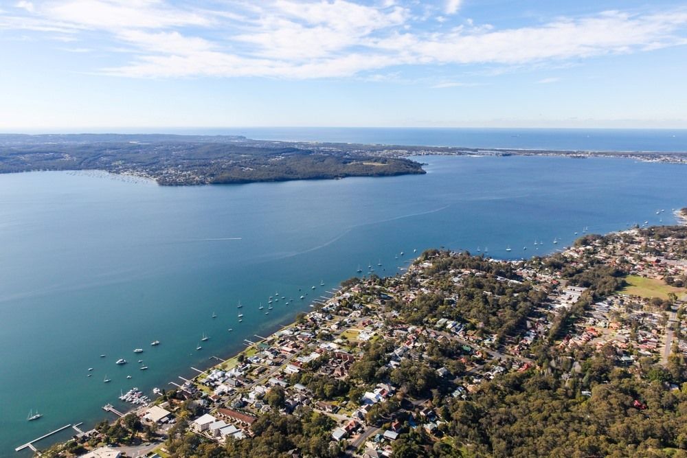 An Aerial View of a Large Body of Water With a Small Island in the Middle — Freedom Flooring Pty Ltd in Lake Macquarie, NSW