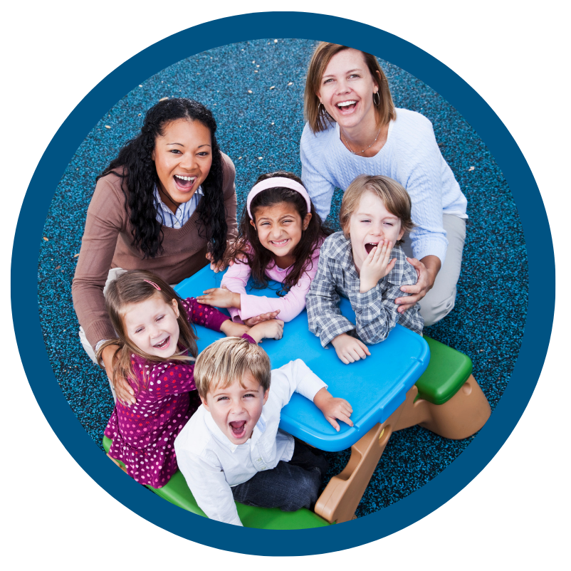 A group of children are sitting around a blue picnic table