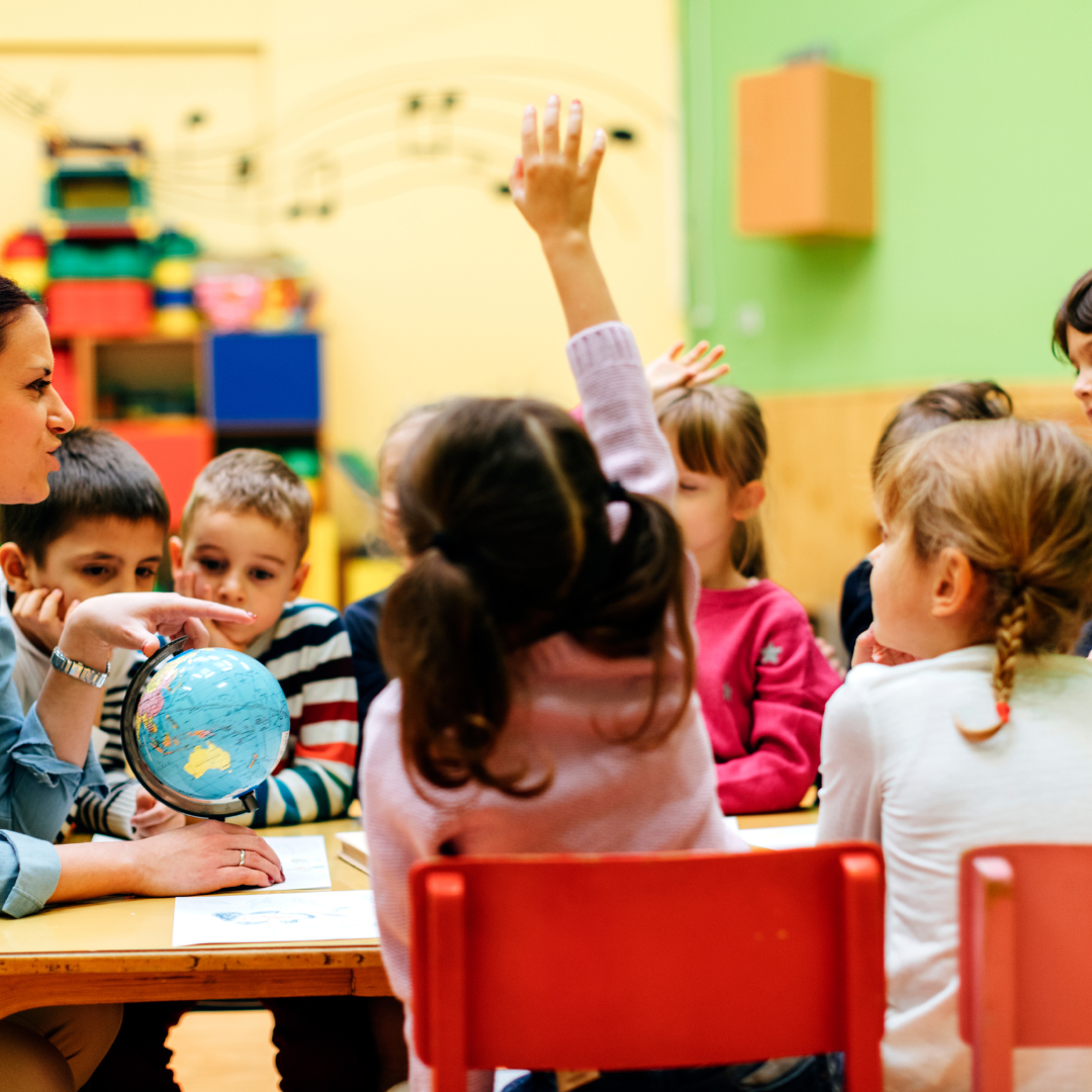 A family is sitting on a couch reading a book together.