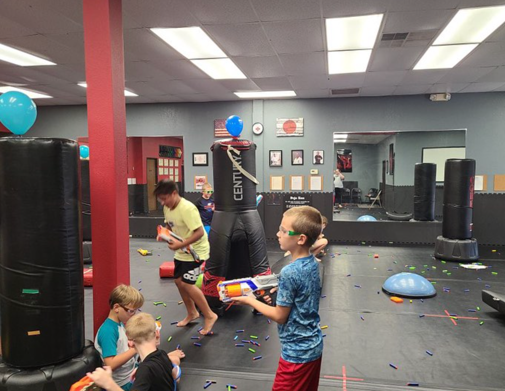 A group of young boys are playing with toys in a gym.