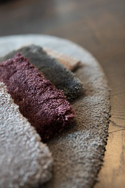 Nahaufnahme von vier Stoffmustern in verschiedenen Grau- und Kastanienbrauntönen