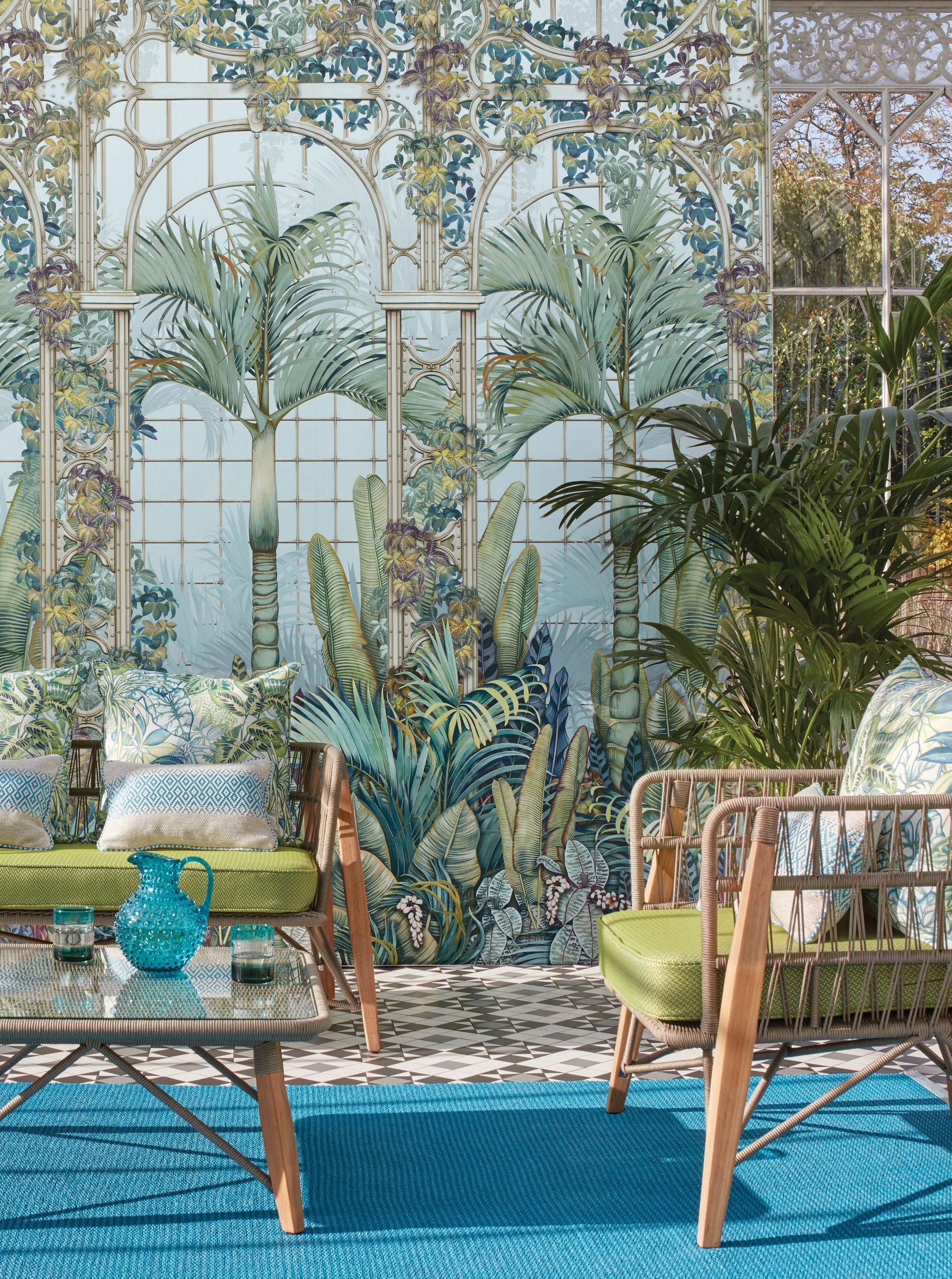 Sitzbereich im Freien mit Palmenmotiv, türkisfarbenen Akzenten und Korbmöbeln.