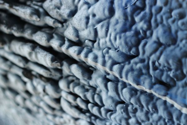 Close-up of textured blue fabric with diagonal folds and ridges