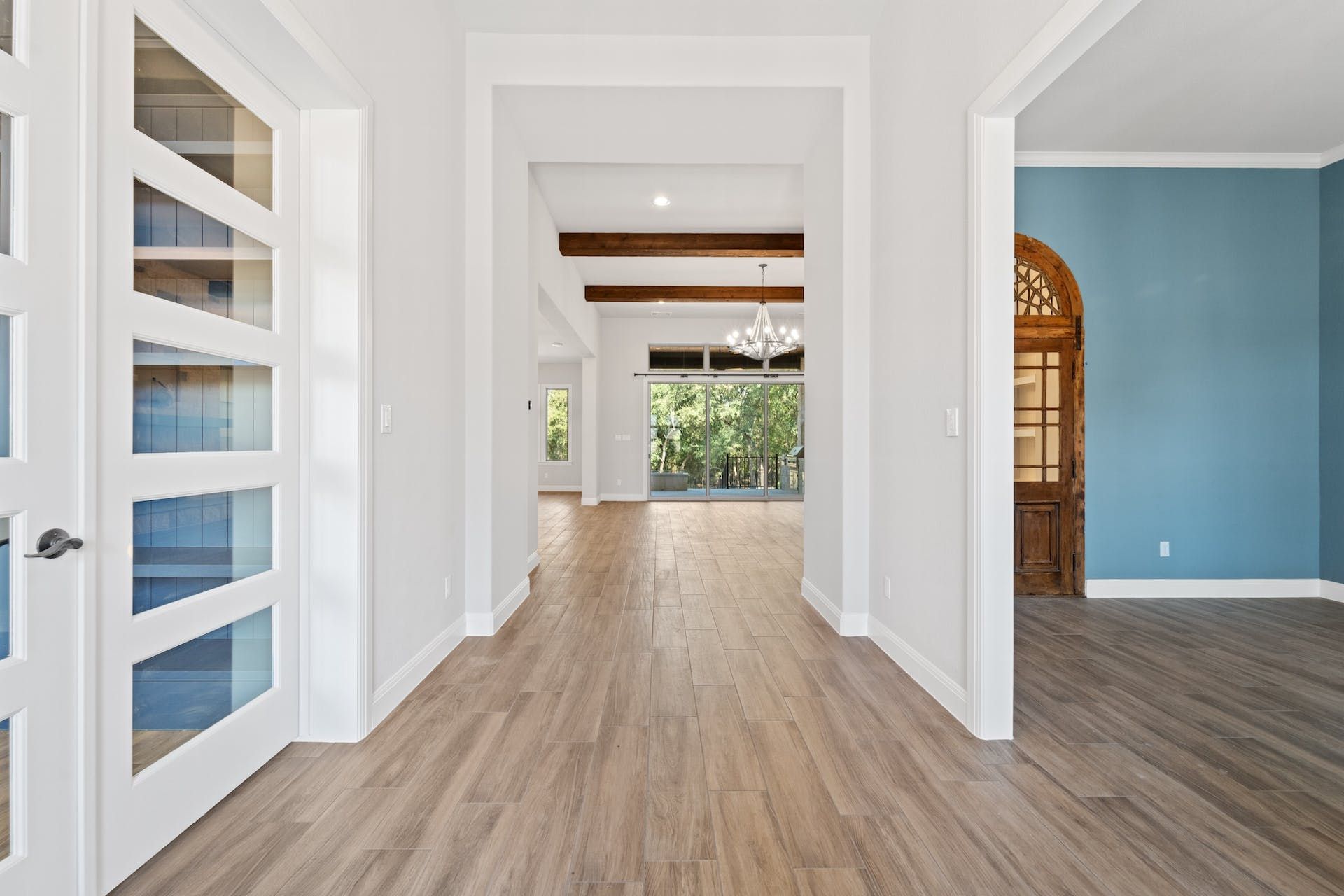A hallway in a house with hardwood floors and blue walls