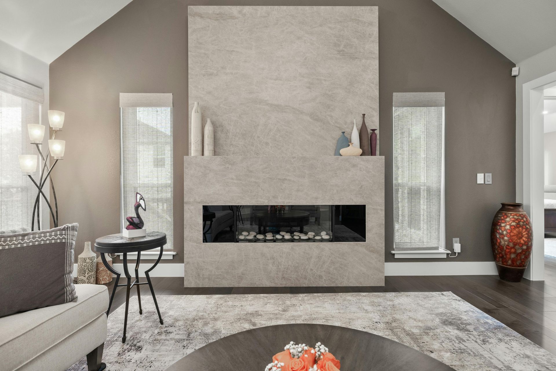 A living room with a fireplace , couch , table and rug.