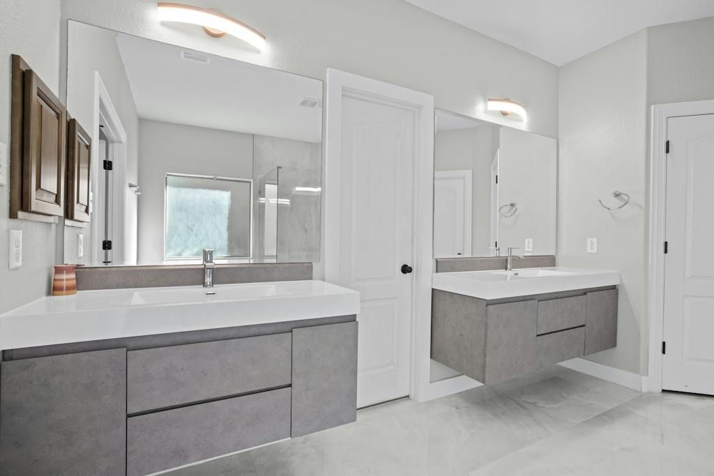 A bathroom with two sinks and a large mirror.