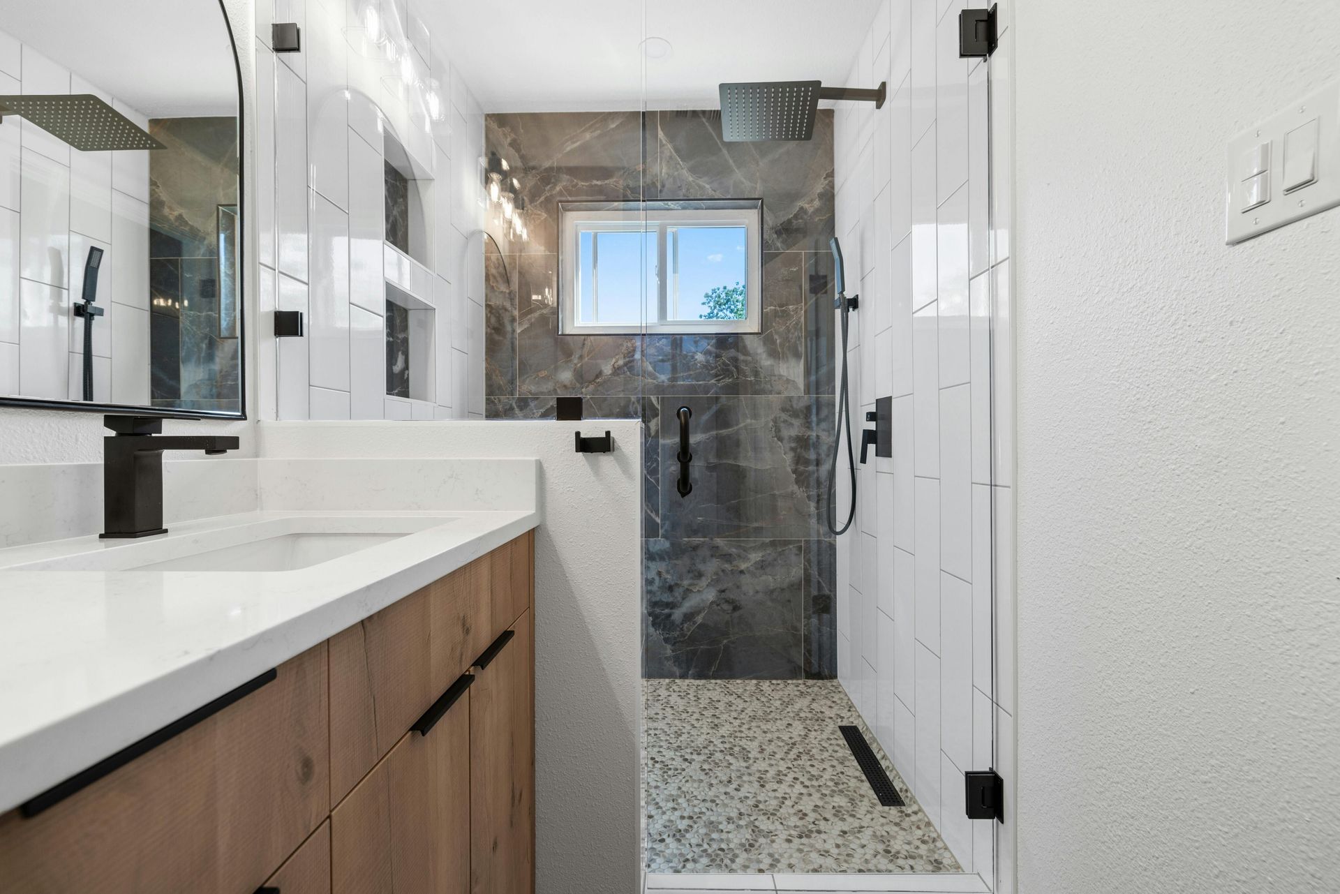 A bathroom with a walk in shower and a sink.