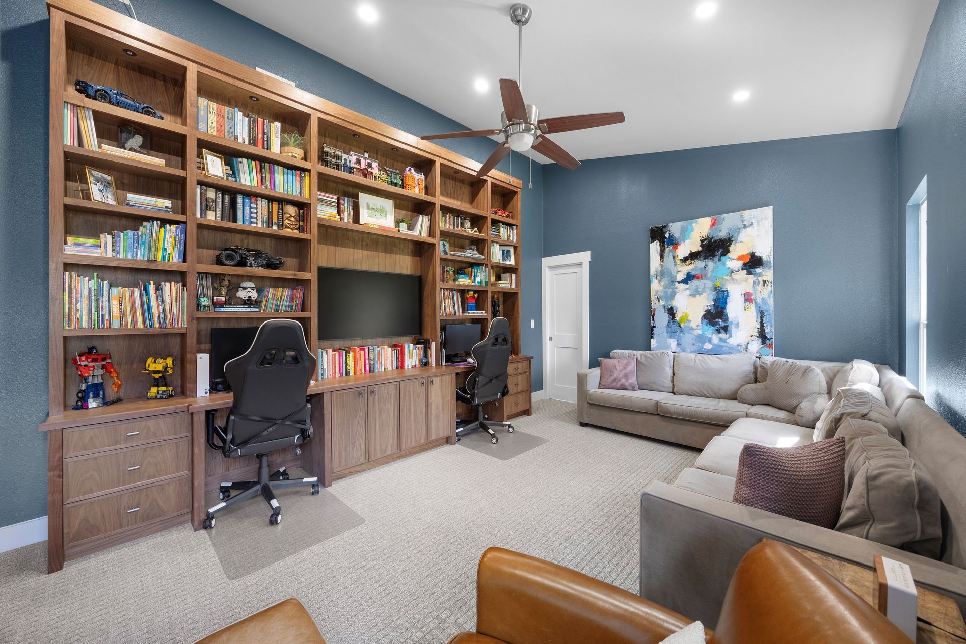 walnut bookshelves and cabinets with lights for library and custom gaming area
