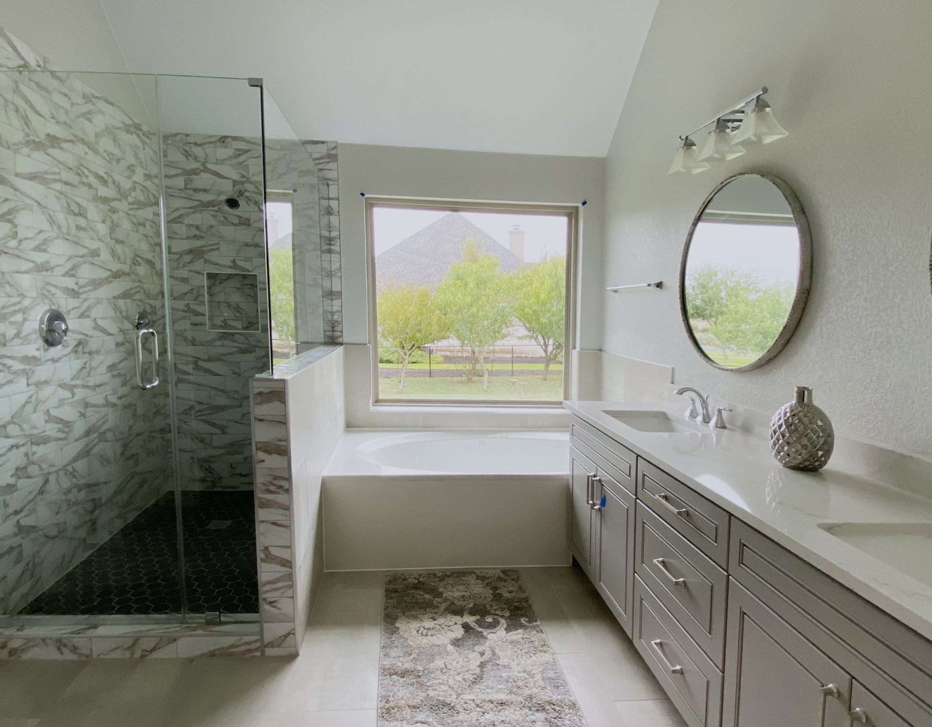 A bathroom with a walk in shower , sink , and mirror.