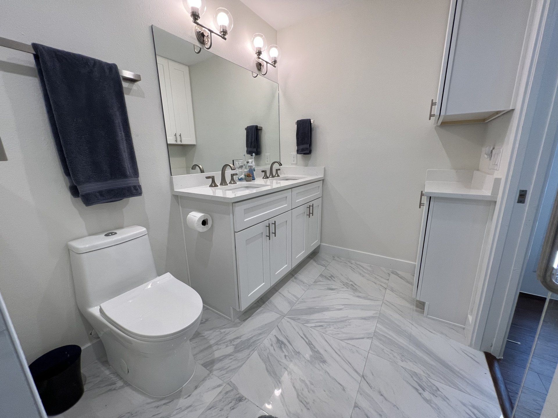 A bathroom with a toilet , sink and mirror.