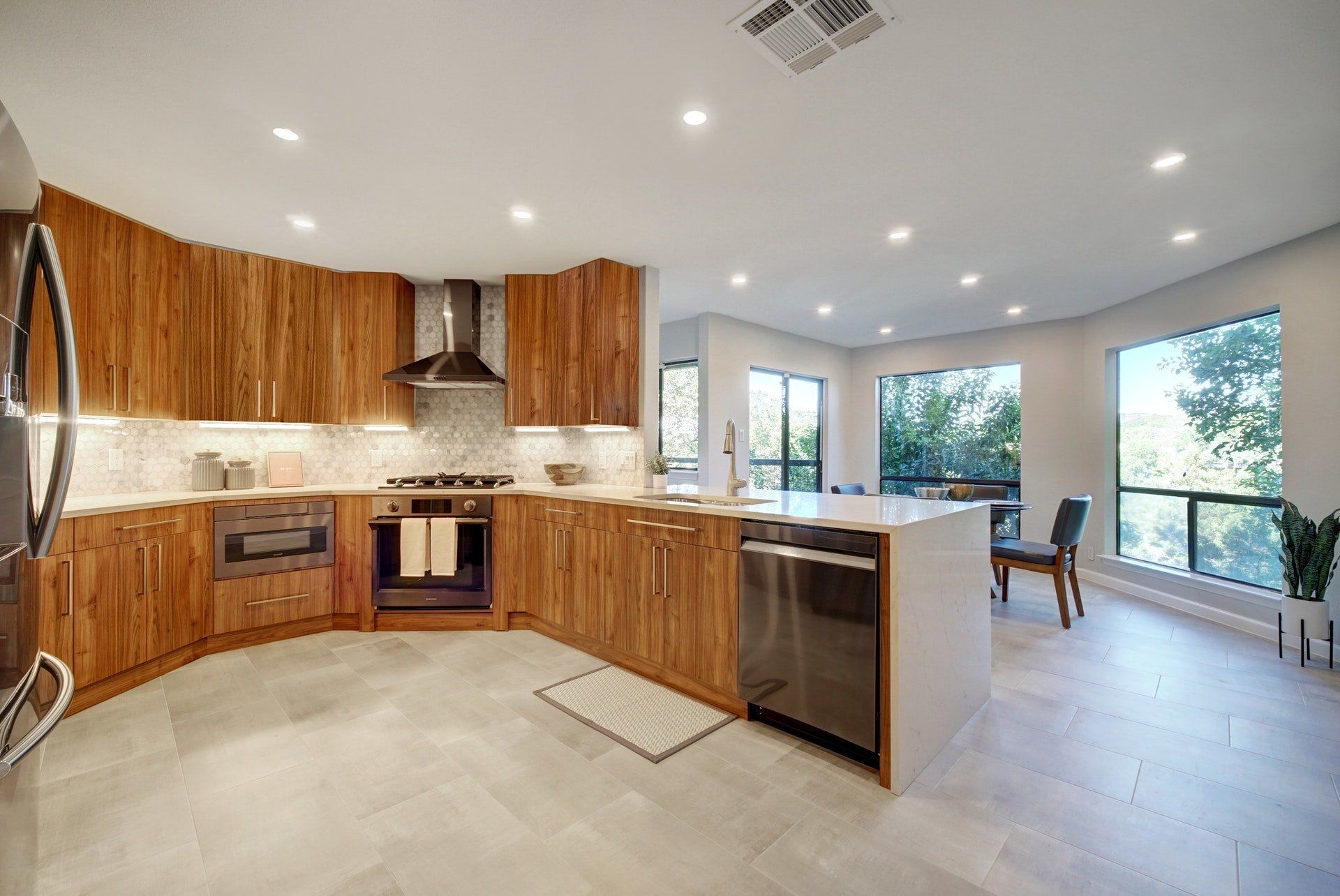 A kitchen with wooden cabinets , stainless steel appliances , and a large island.