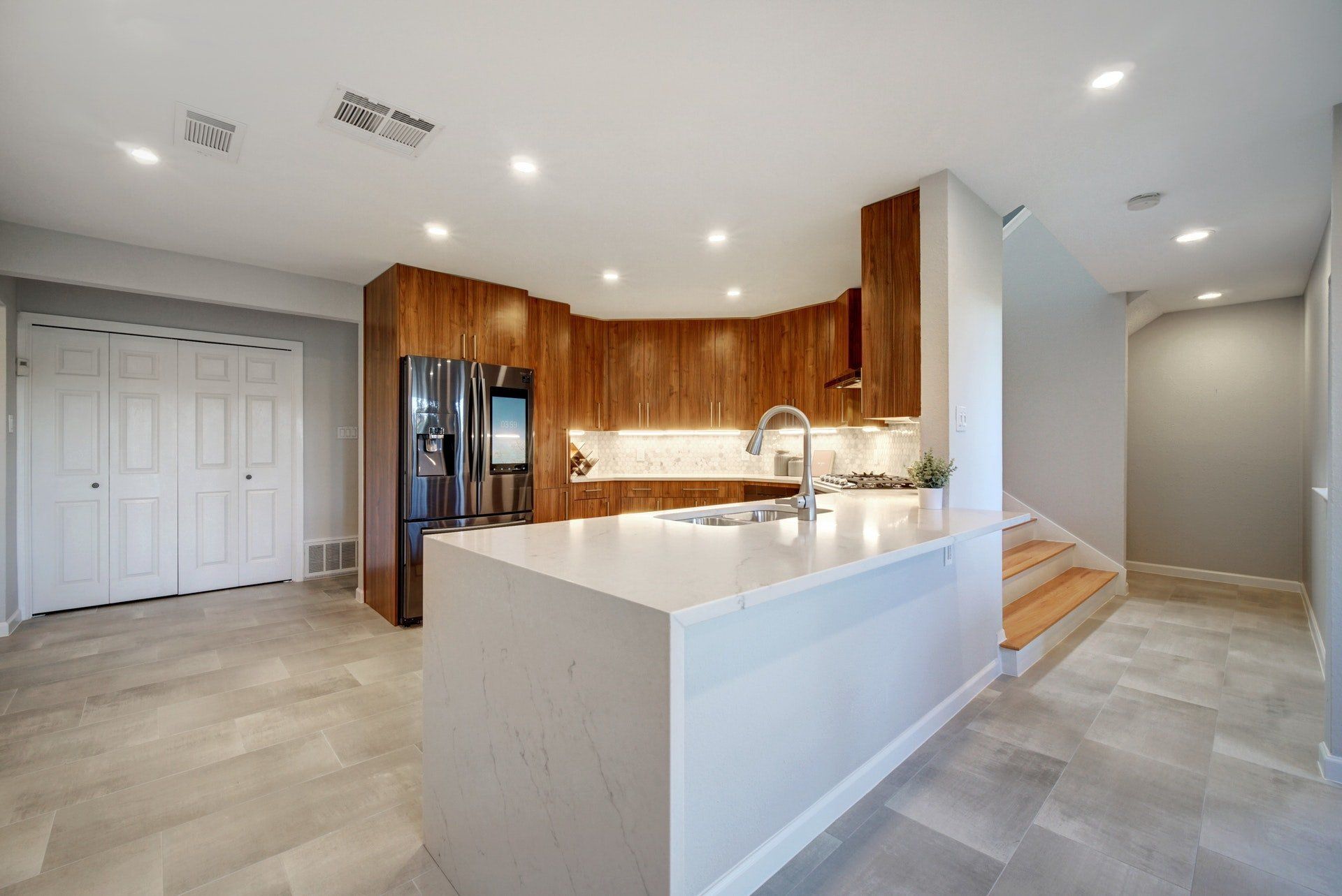 A kitchen with a large island and a refrigerator.