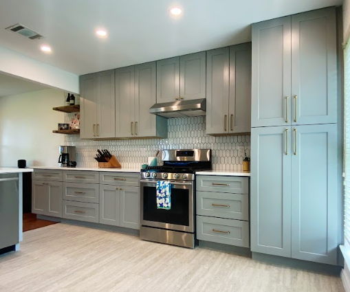 A kitchen with gray cabinets and stainless steel appliances