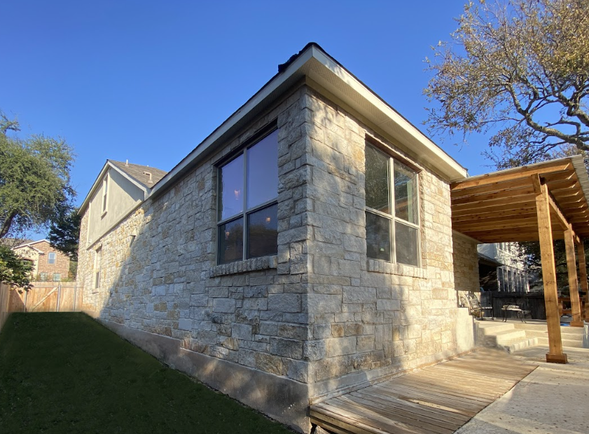 A brick house with a pergola and a lot of windows