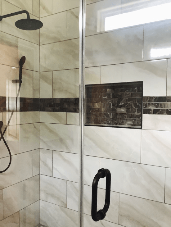 A shower with a glass door and a shower head