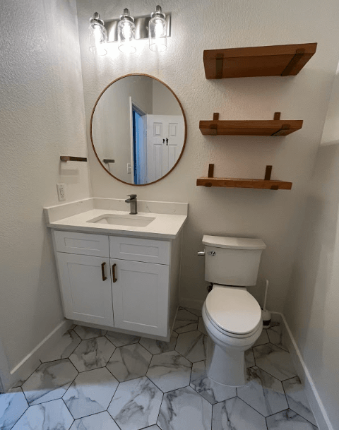 A bathroom with a toilet a sink and a mirror