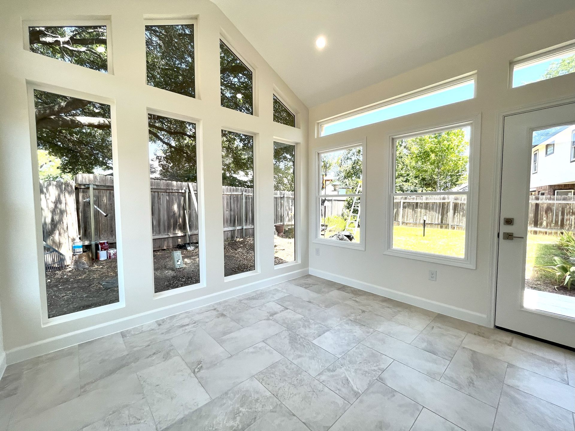 An empty room with a lot of windows and a door.