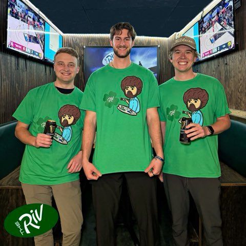 Three men wearing green shirts with bob ross on them