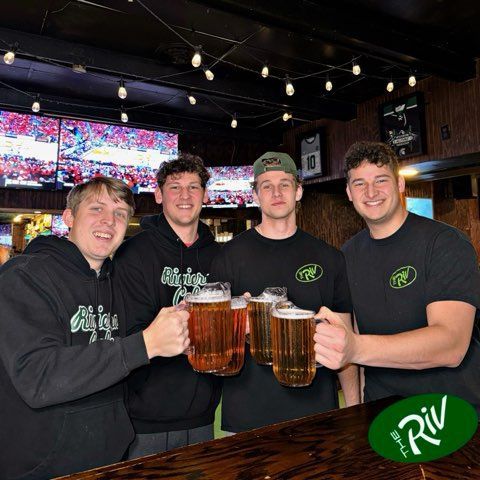 A group of men are holding mugs of beer in a bar.