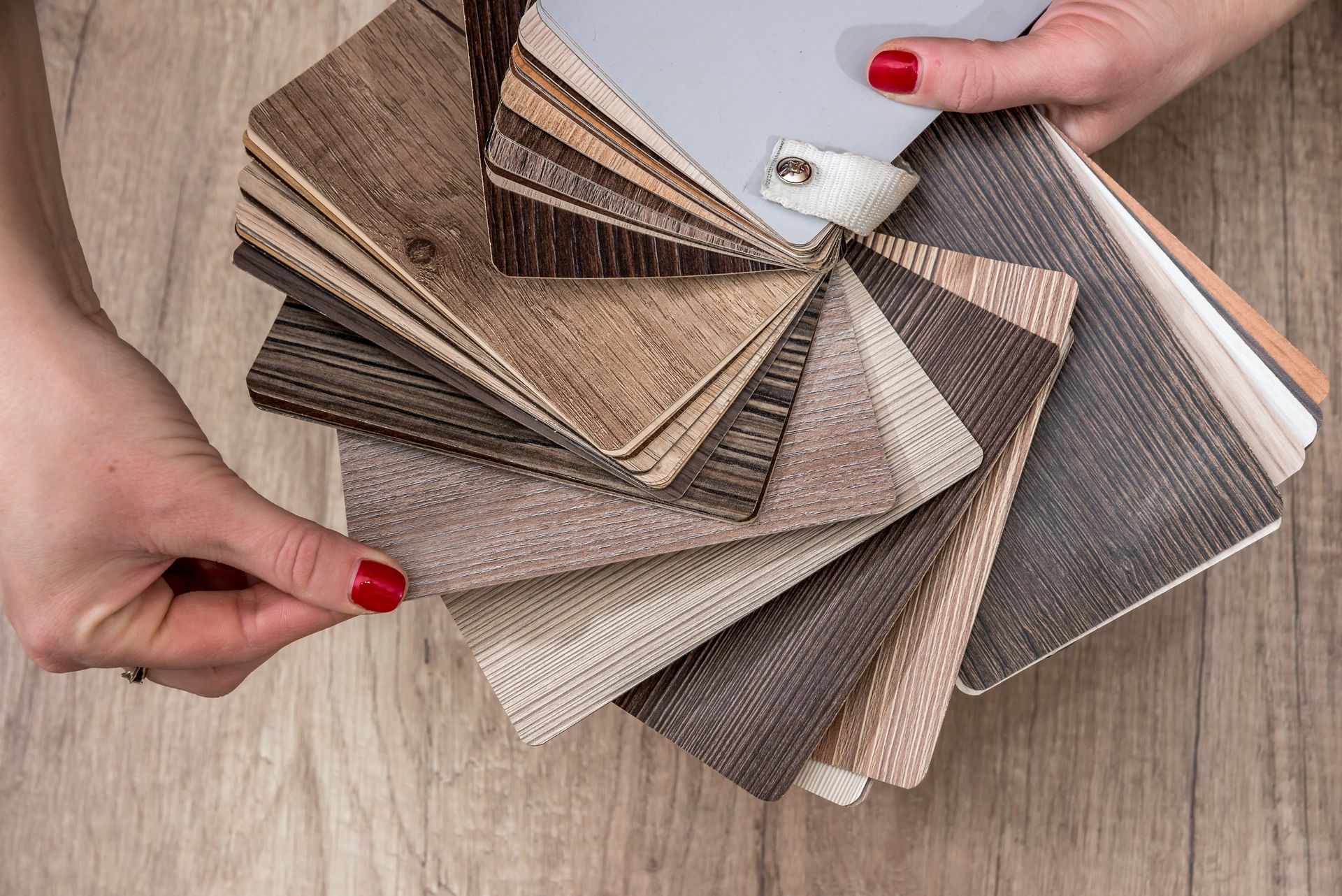 Women showing Samples of laminate and vinyl floor tile.