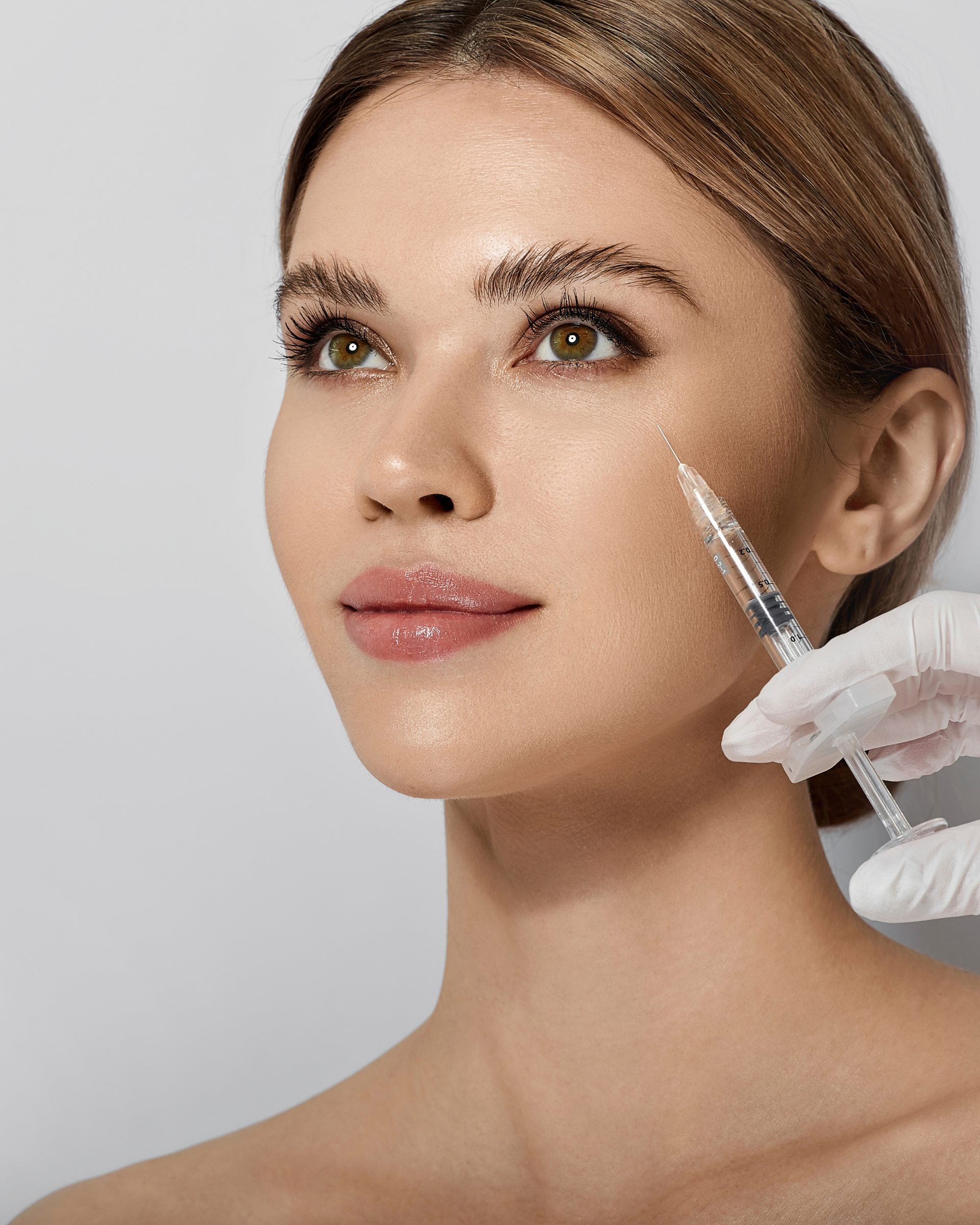 A woman is getting a botox injection in her face.