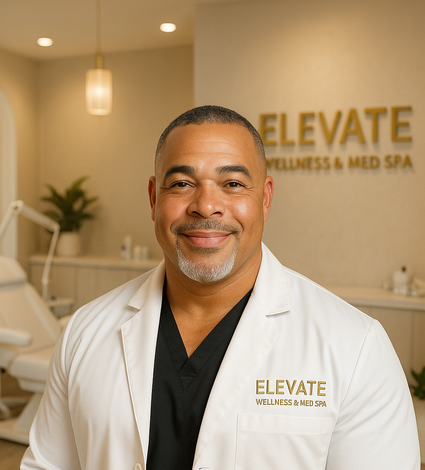 A man in a white coat with elevate wellness and med spa written on the wall behind him