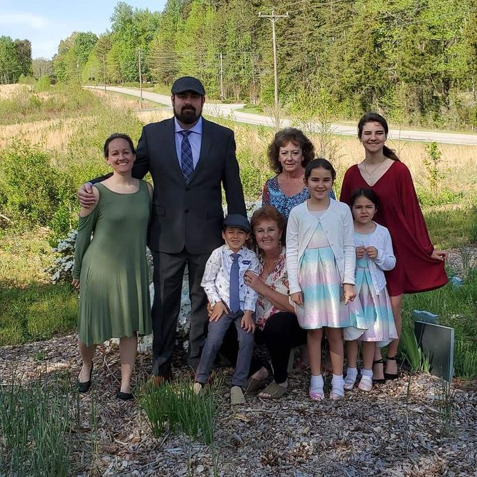 A group of people are posing for a picture in a field.