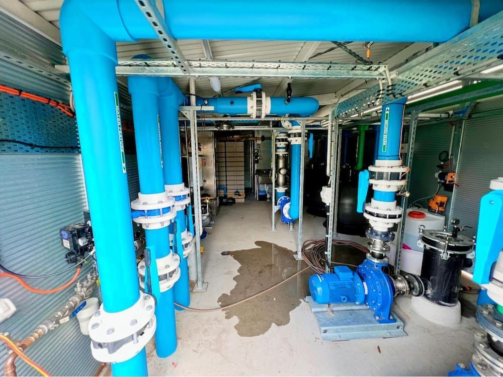 A Room Filled With Lots of Blue Pipes and Pumps — CJM Plumbing & Roofing Mackay in Mackay, QLD