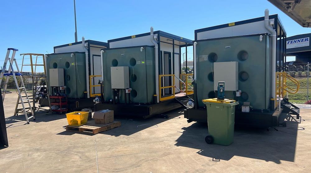 A Row of Trailers Are Parked Next to Each Other in a Parking Lot — CJM Plumbing & Roofing Mackay in Mackay, QLD