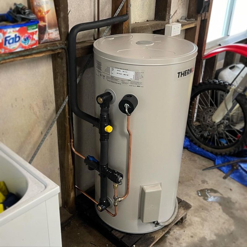 A Drain Pipe is Being Installed in the Dirt in Front of a House — CJM Plumbing & Roofing Mackay in Marian, QLD