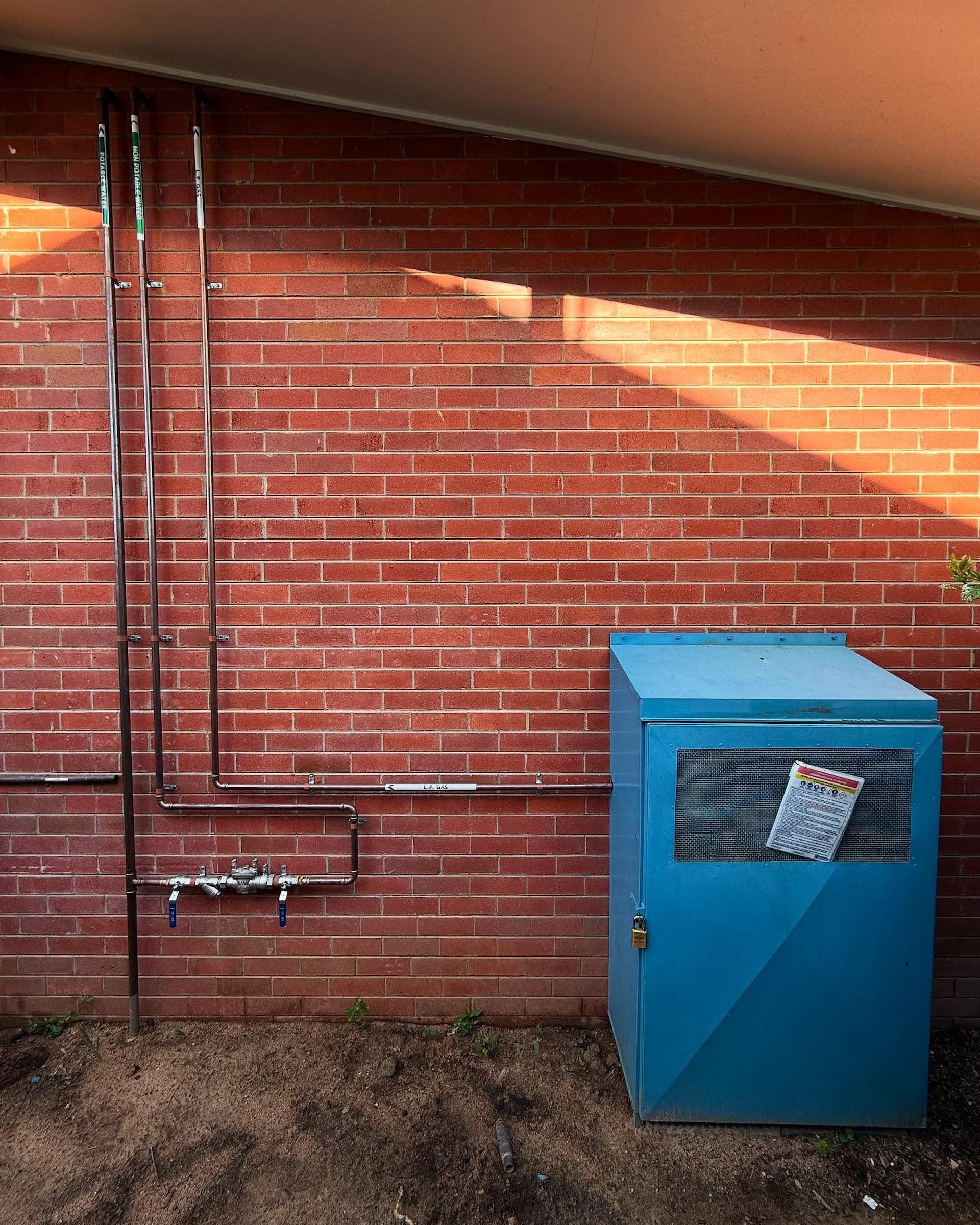 A Man Wearing a Blue Shirt That Says a & B Plumbing on It — CJM Plumbing & Roofing Mackay in Mackay, QLD