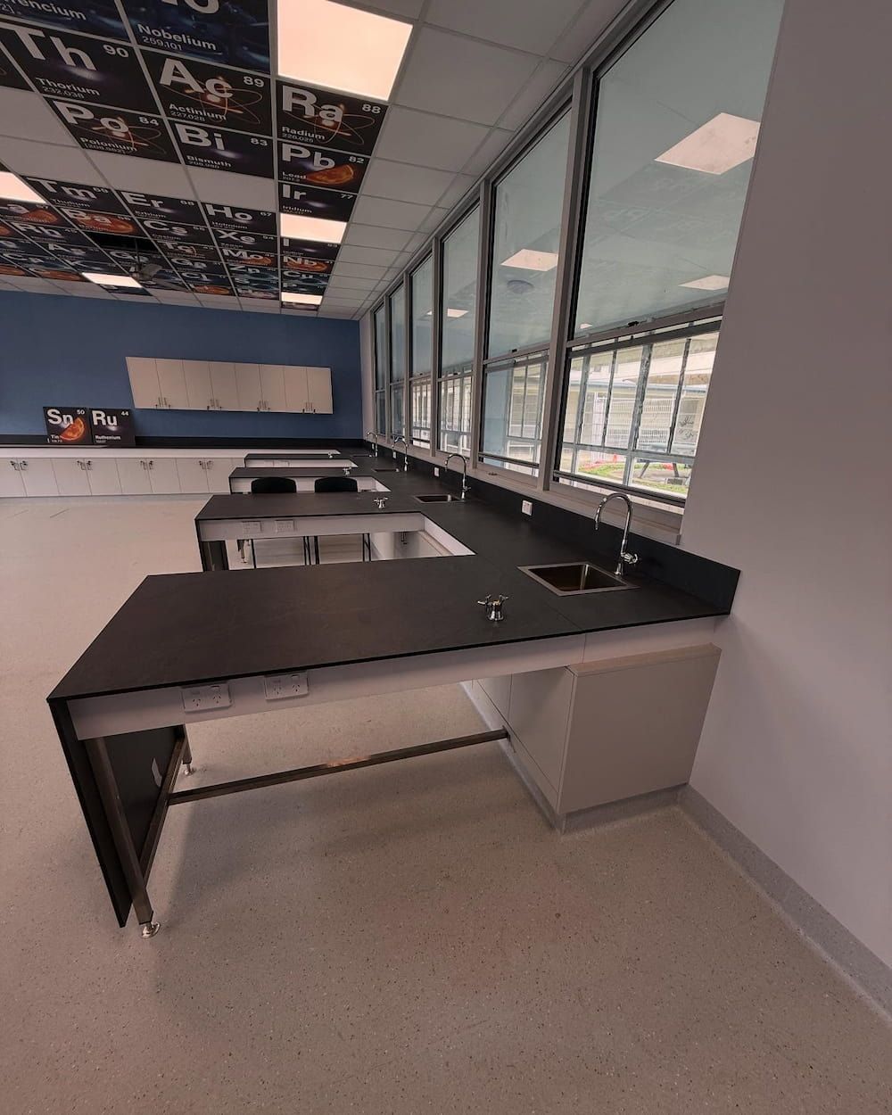 A Classroom With a Lot of Windows and a Black Table — CJM Plumbing & Roofing Mackay in Marian, QLD