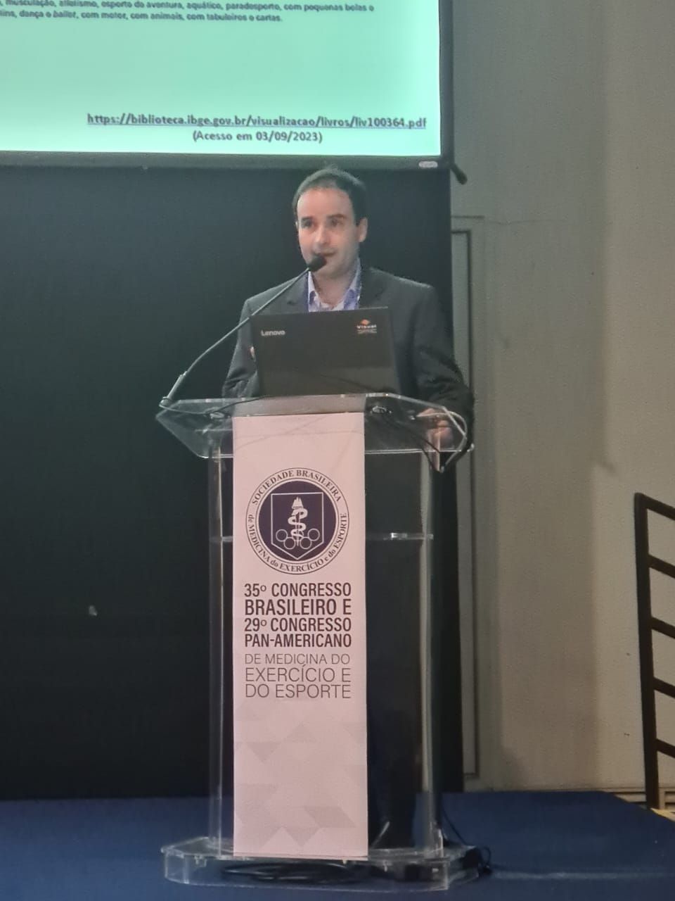 Um homem está em um pódio fazendo uma apresentação