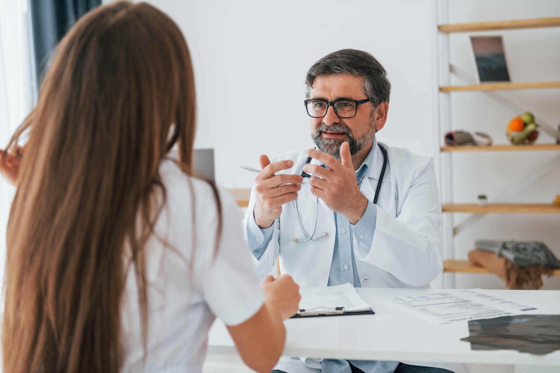 Um médico está conversando com um paciente sentado à mesa.