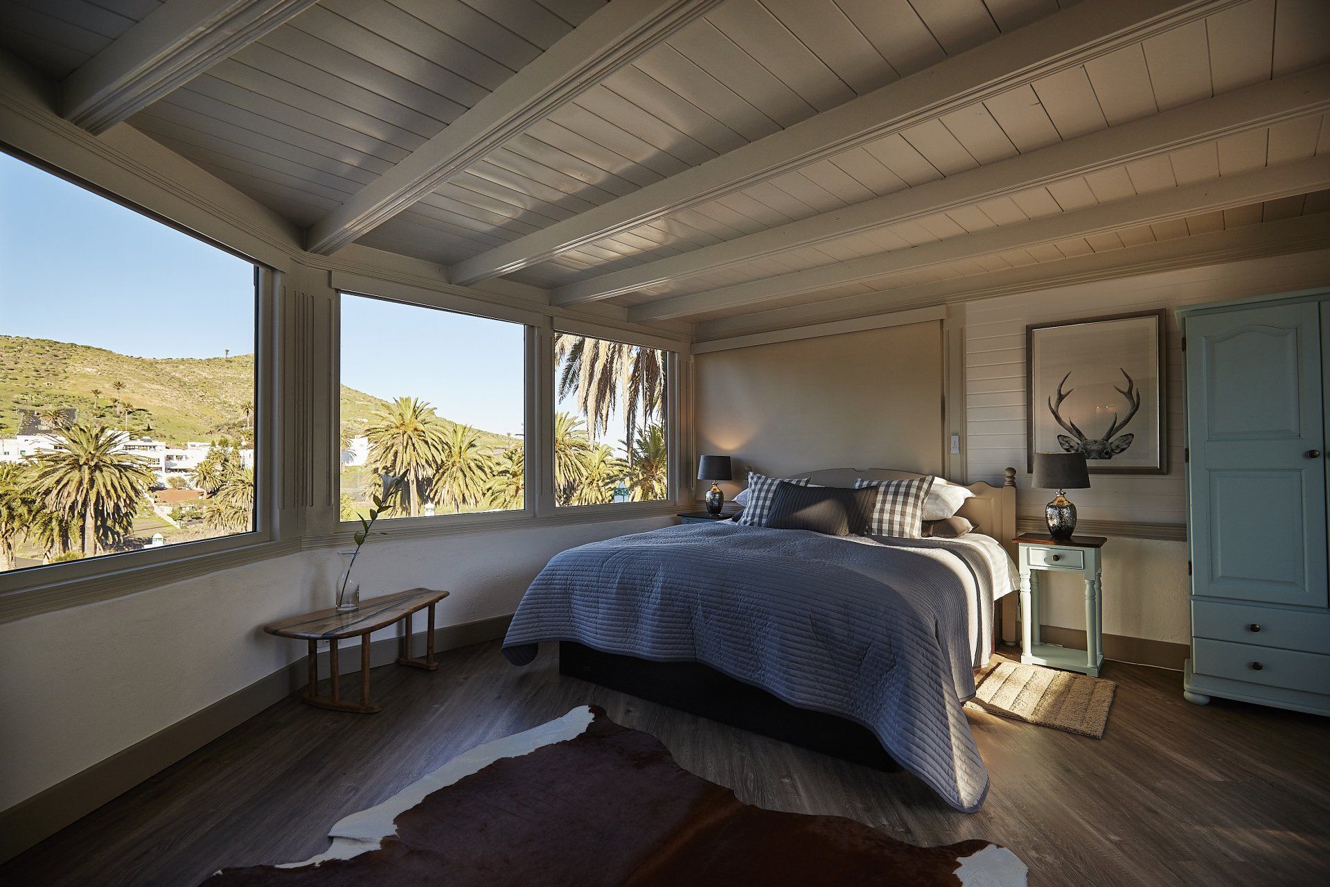 A bedroom with a large bed and lots of windows