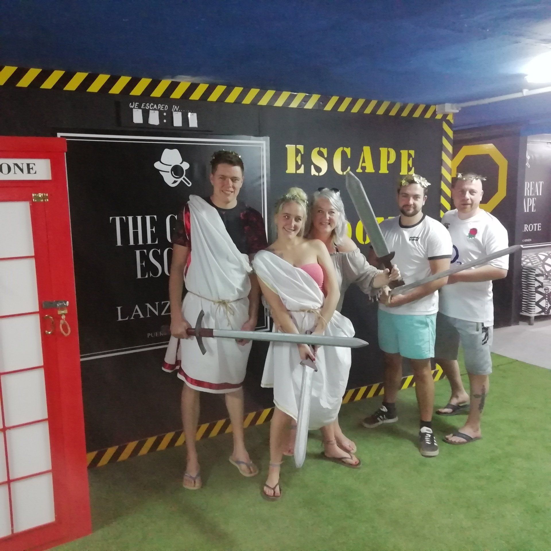 A group of people standing in front of a sign that says escape room