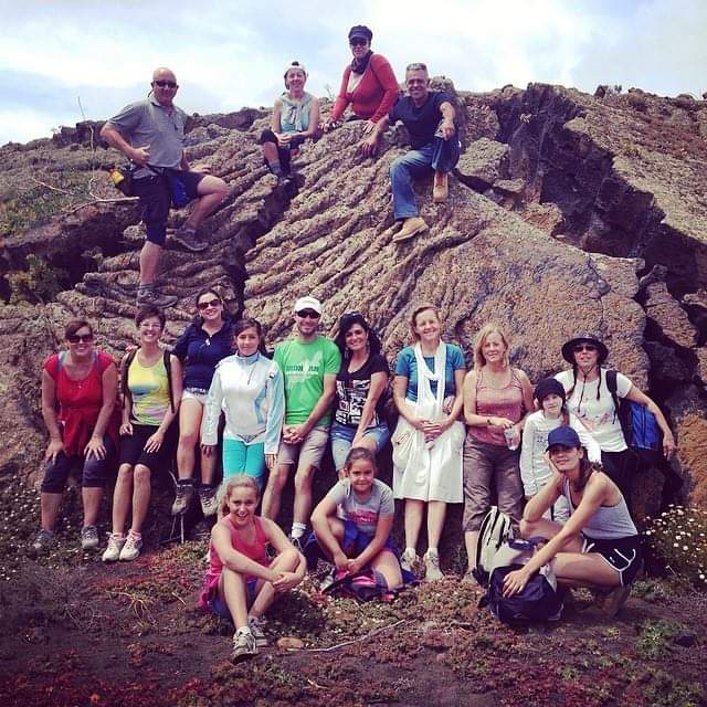 A group of people posing for a picture on a rocky hillside on Lanzarote island