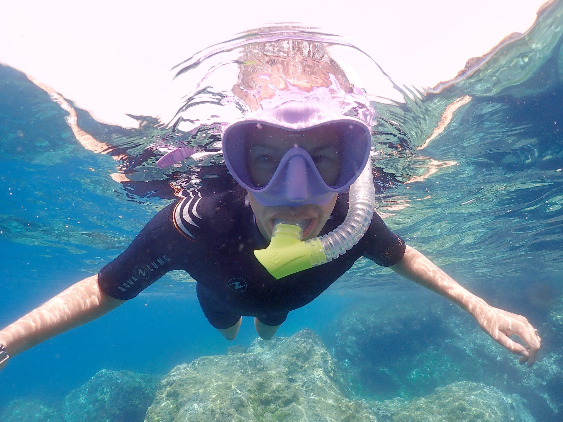 A person wearing a mask and snorkel is swimming in the ocean