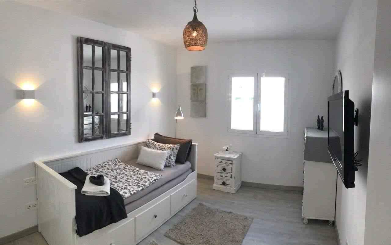 A bedroom with a day bed and a flat screen tv